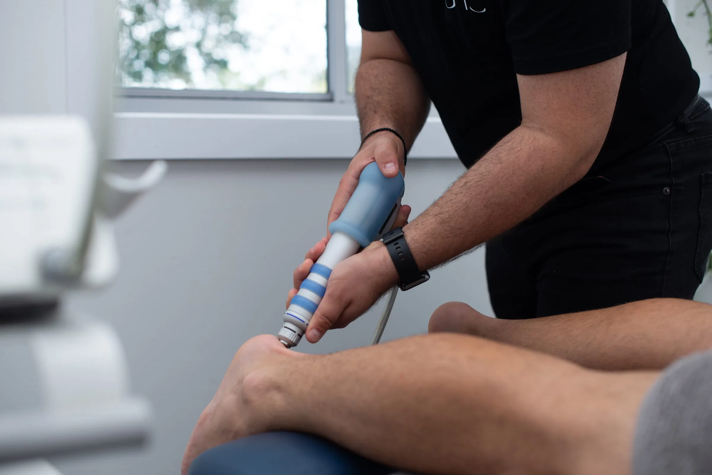 Radial shockwave therapy applied to a patient's leg