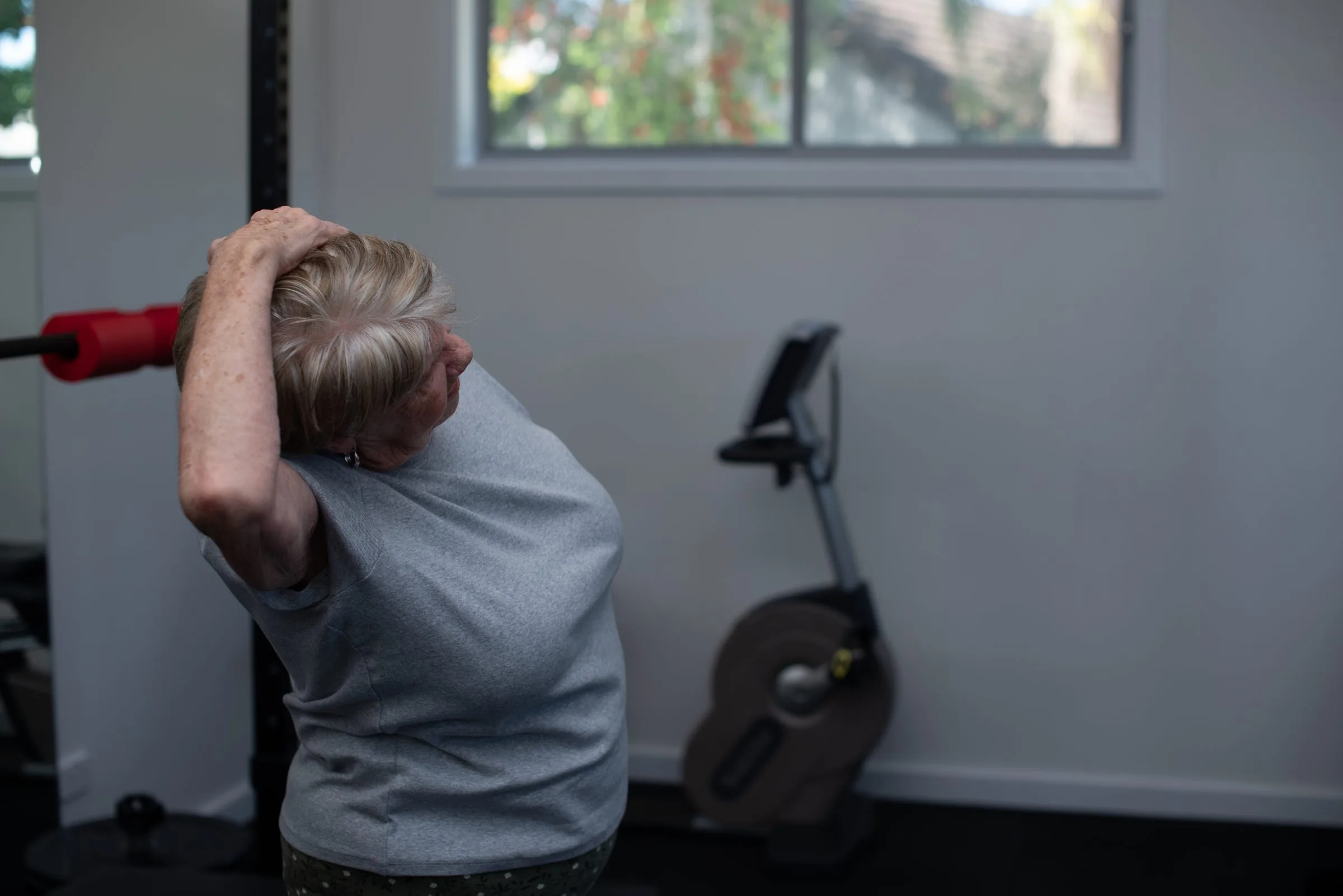 Exercise physiologist supervising a client in the gym