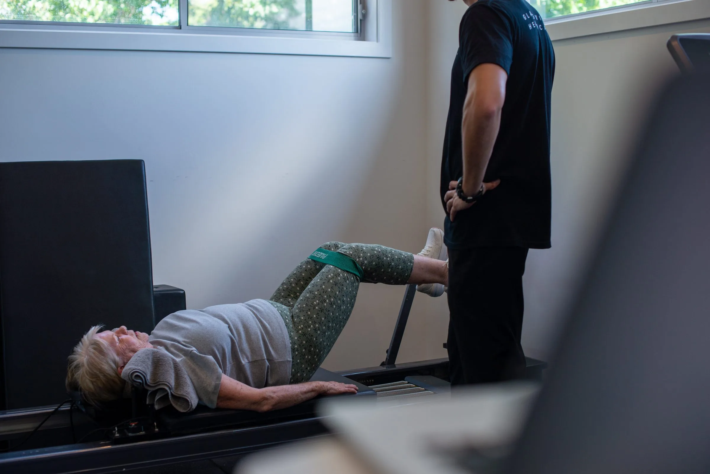 Physiotherapist guiding a patient through an exercise in the clinic gym