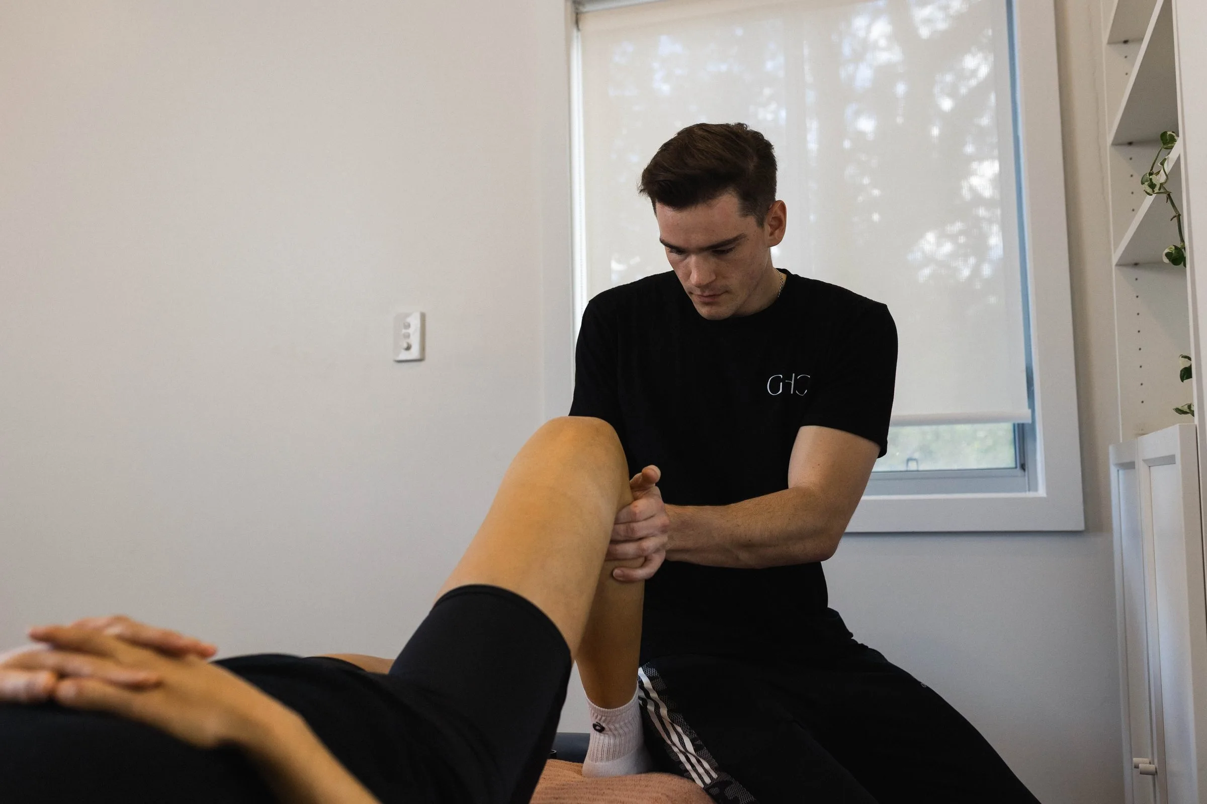 Practitioner mobilising a patient's joint on the treatment couch
